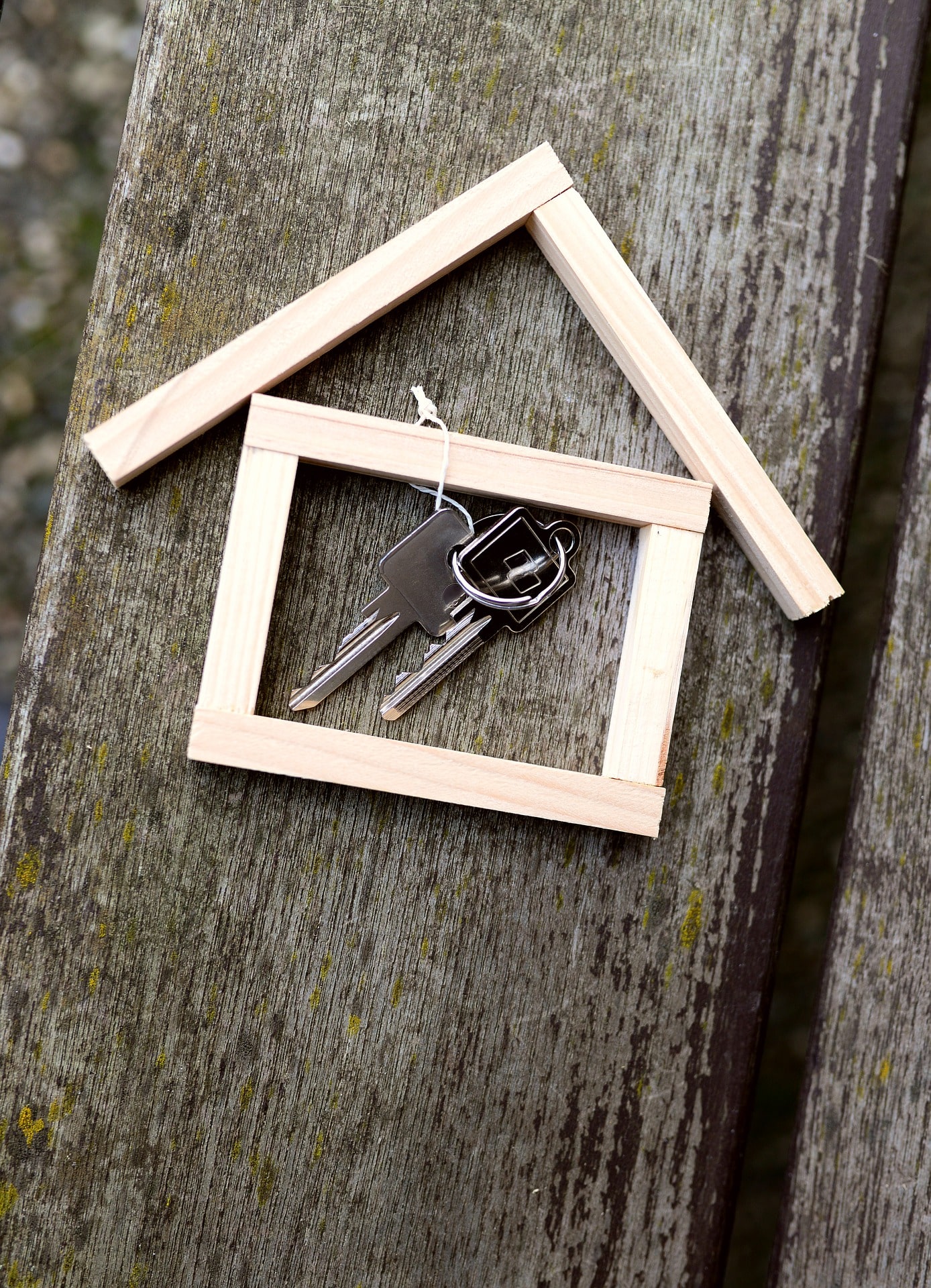 Six pieces of wood arranged in the shape of a house icon with a set of keys inside